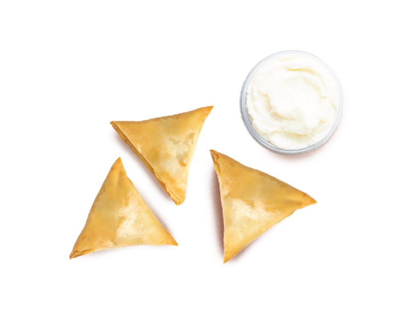 Samosa pastry with a spiced filling, shown with a selection of dipping sauces